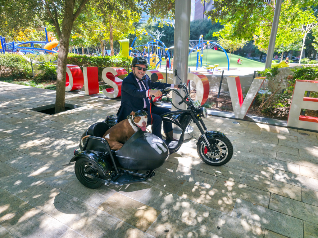 Attorney Adam Miller and his sidekick McLovin’ on a motorcycle with a sidecar in a Houston park