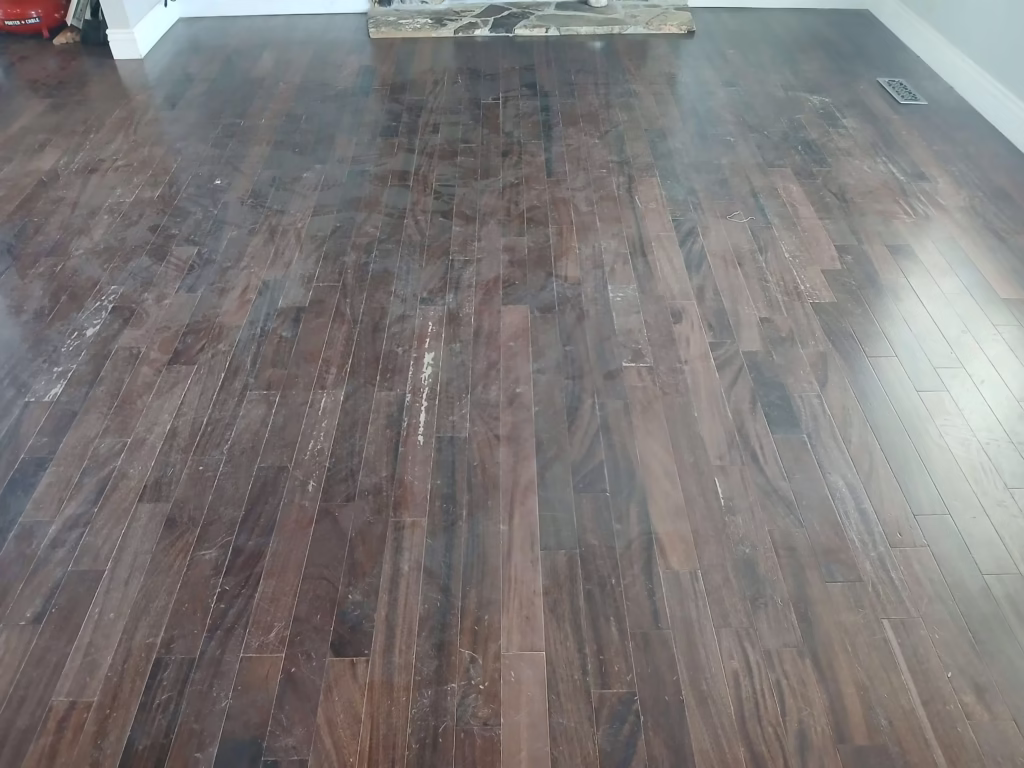 a room with unfiinished walnut floors and a fireplace