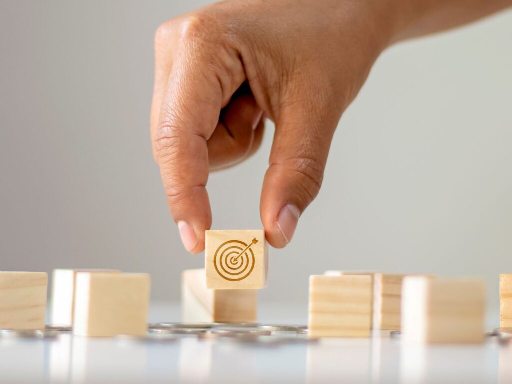 hand holding a block with a target symbol on it