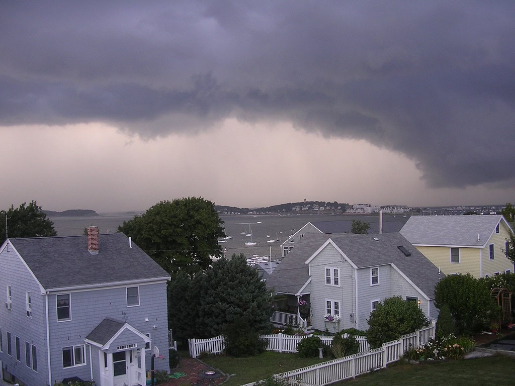 A storm front approaching a coastal neighborhood, a reminder for Gulf Coast rental owners to prepare before hurricane season peaks