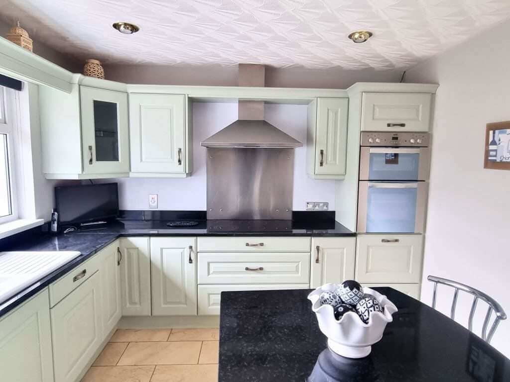 Modern kitchen with light green cabinets and island