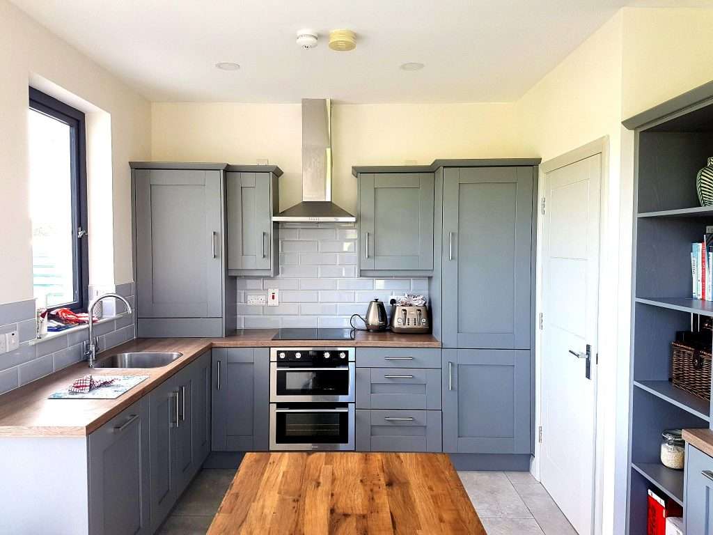 Modern kitchen with gray cabinets and island.