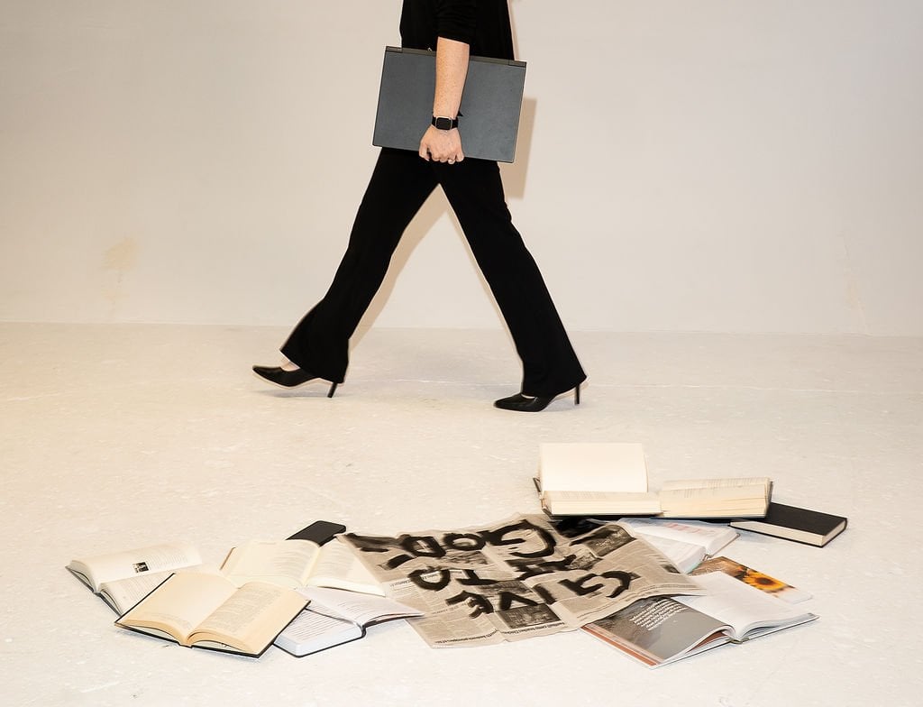 Carly walking next to books and Bible