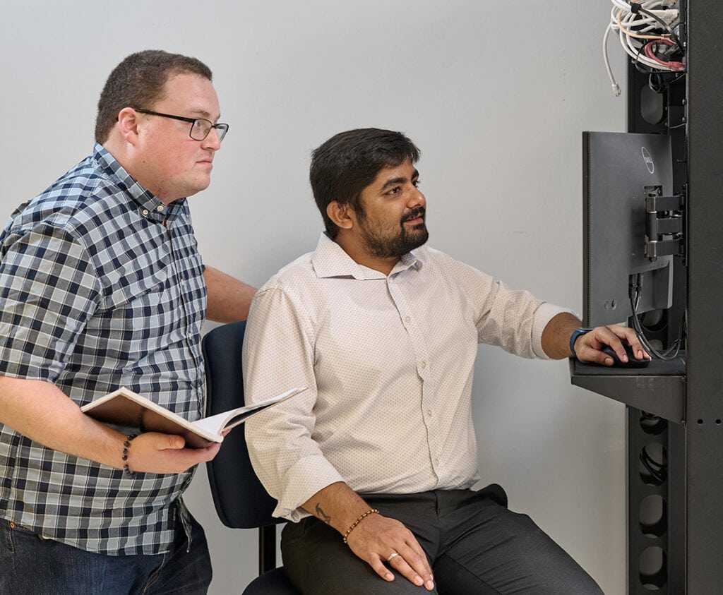 Two IT professionals working on a server