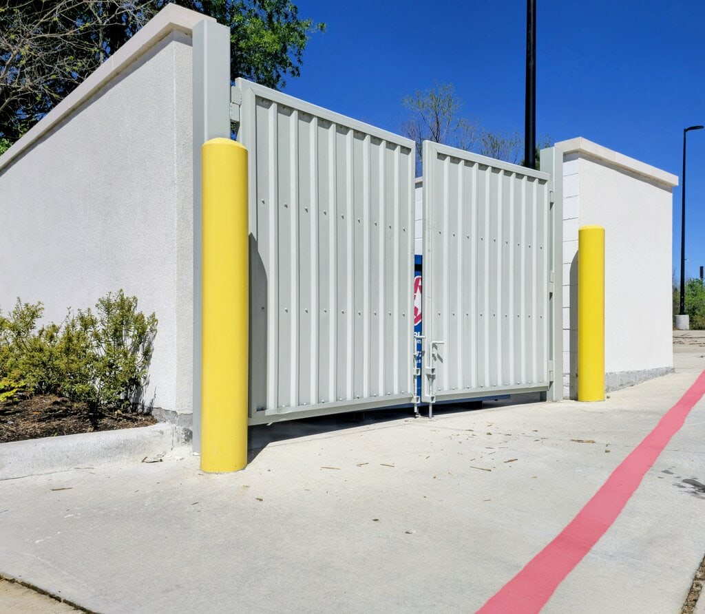 Yellow bollards along a red fire lane stripe at a commercial property