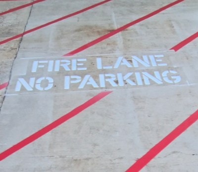 Yellow bollards along a red fire lane stripe at a commercial property