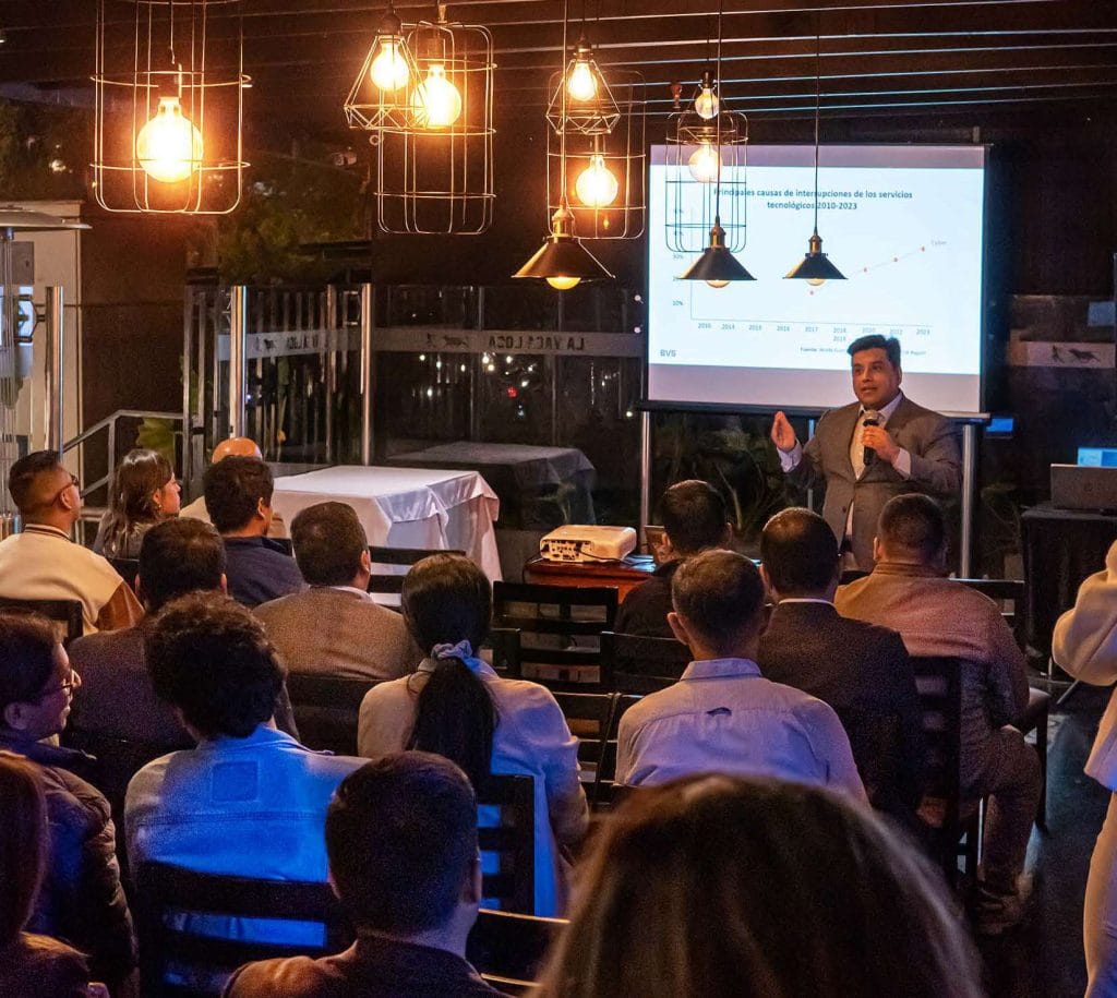 Expositor presentando una charla corporativa frente a un público sentado en la terraza de La Vaca Loca