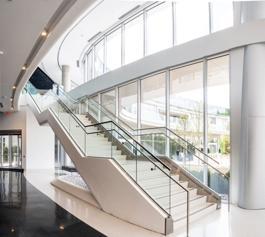 Natural light falls on a modern staircase connecting the first and second floors of 1000 Social, a luxury office space in Raleigh