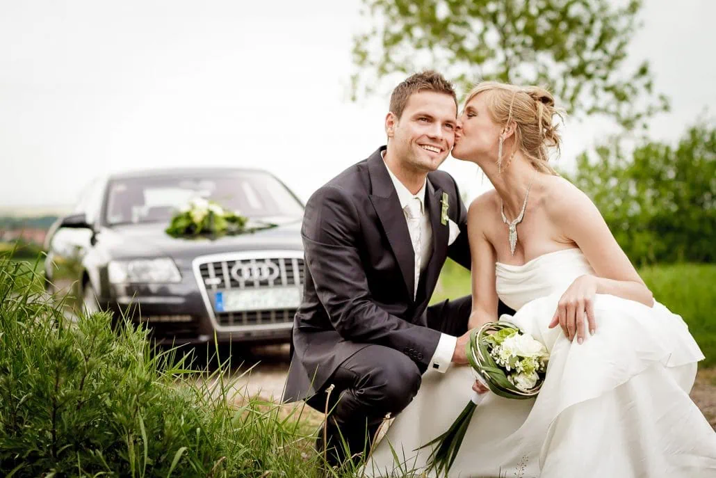 Brautpaar mit Hochzeitsauto im Hintergrund fotografiert in Thüringen