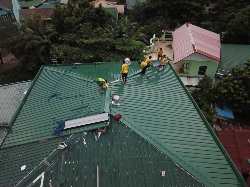 Licensed roofing contractors working on the repair of a residential roof.
