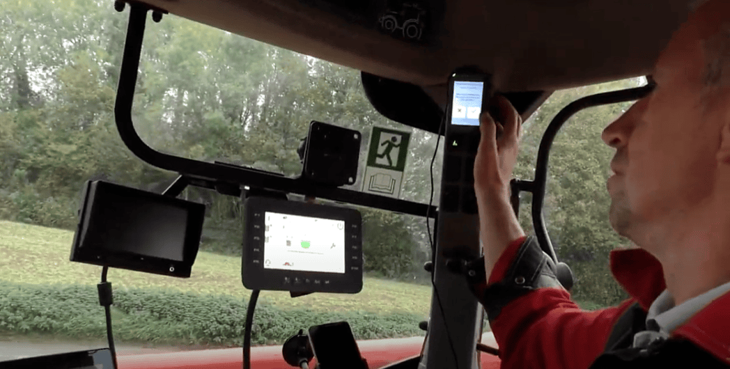 Agriculteur dans un tracteur manipulant des outils digitaux