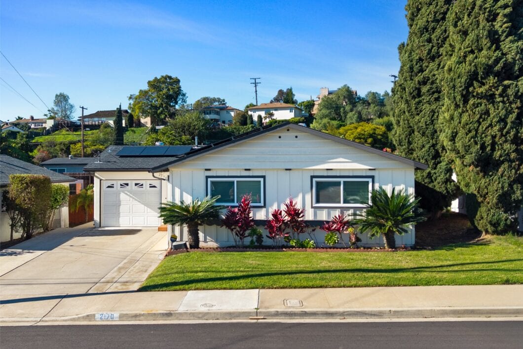 Exterior view of the residential property at 2170 Montclair St, North Park, featuring a white garage, solar panels, and manicured front lawn.