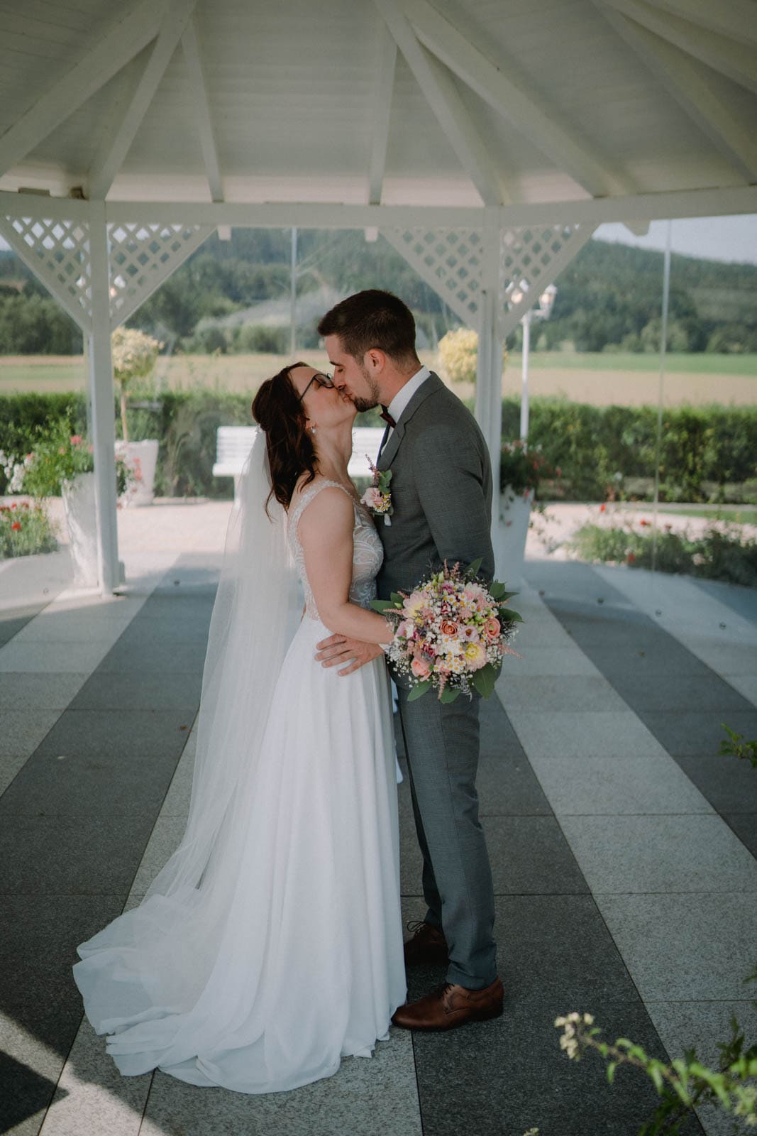 Küssendes Brautpaar unter Pavillion