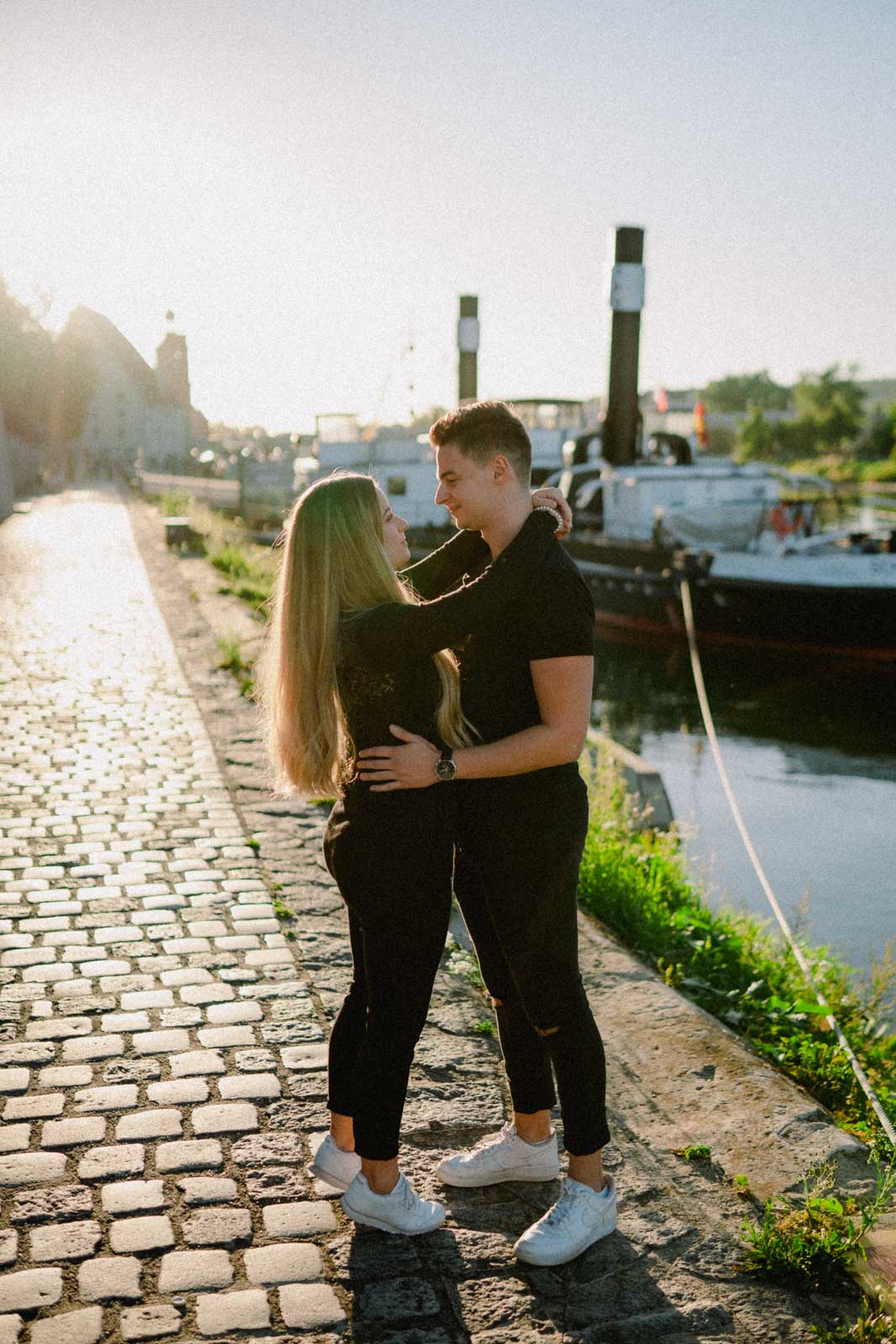 Pärchen blickt sich bei Sonnenuntergang an der Donau in die Augen