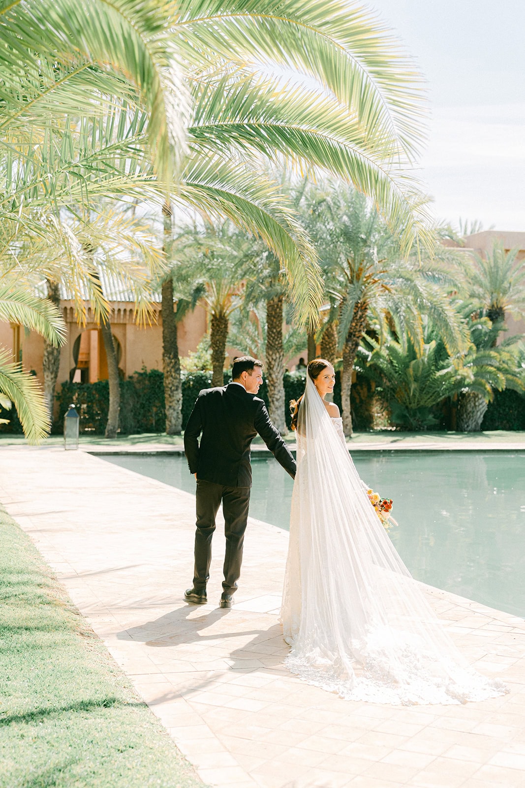 Andrea Gallucci - Destination Wedding Photographer- Amalfi Coast Positano Santorini Barcellona Rome Ravello Paris New York Candid moment during styled Morocco wedding shoot with the couple walking through Amanjena