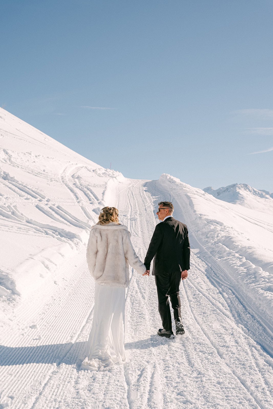 Andrea Gallucci - Destination Wedding Photographer- Amalfi Coast Positano Santorini Barcellona Rome Ravello Paris New York Bride and groom walking hand in hand during a winter mountain wedding