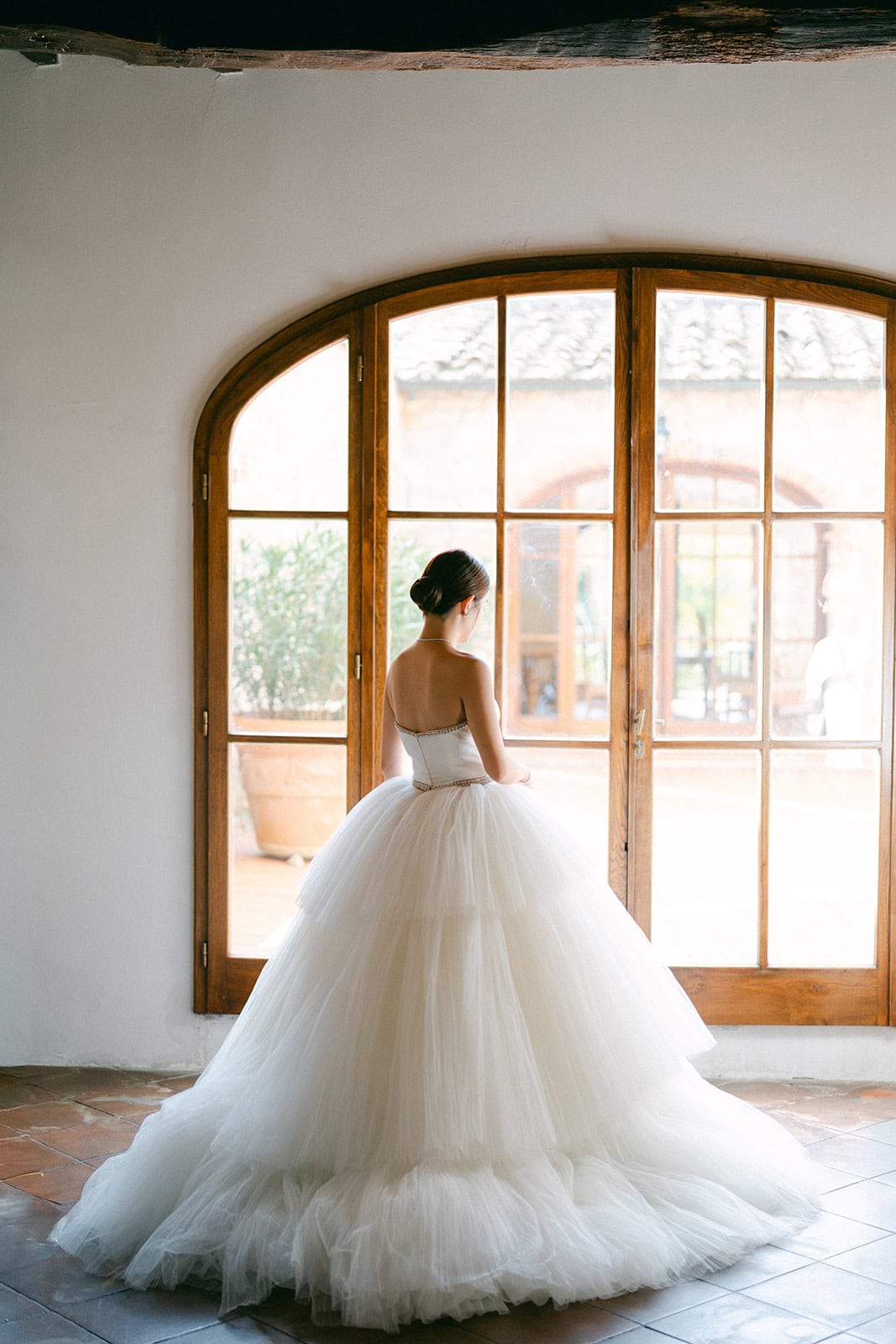 Bride standing by window during getting ready pictures wedding session