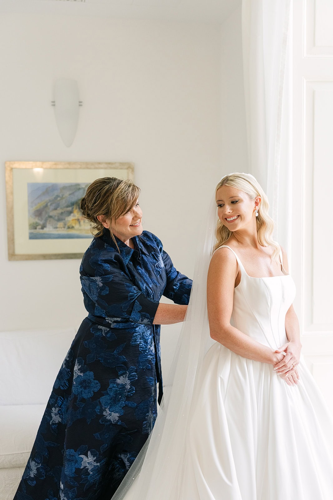 Mother of the bride helping bride into dress during getting ready pictures wedding