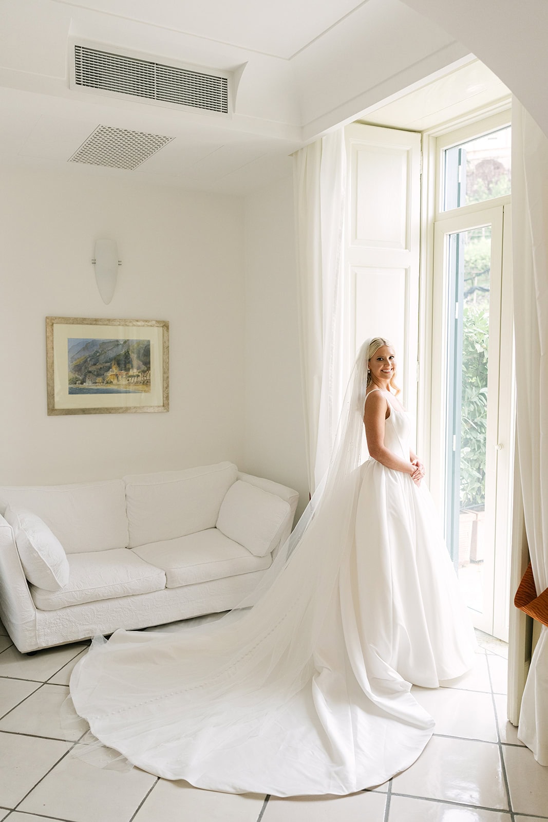 Wedding morning bride putting on dress with soft natural light