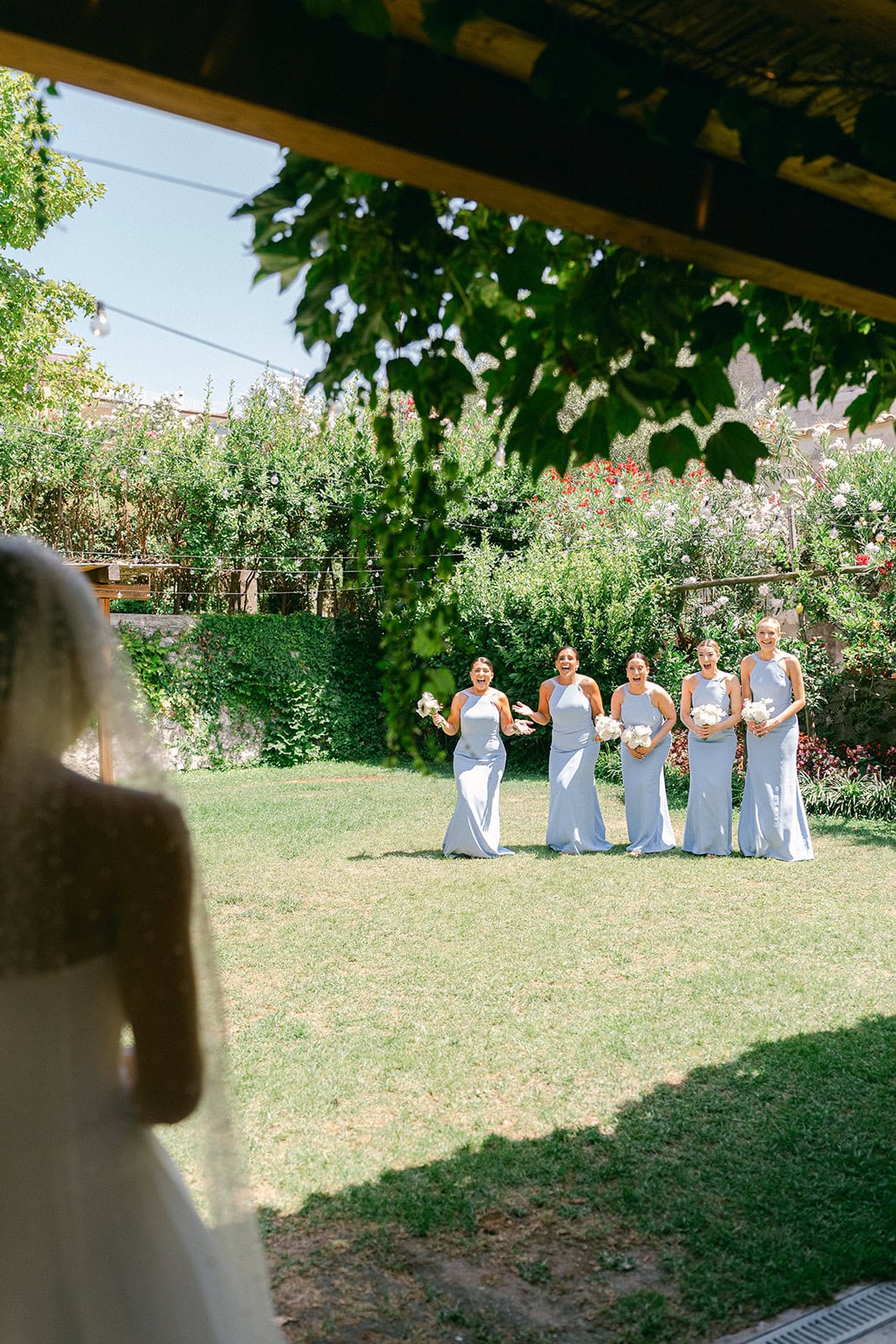 Bridesmaids reacting to bride in dress during getting ready pictures wedding