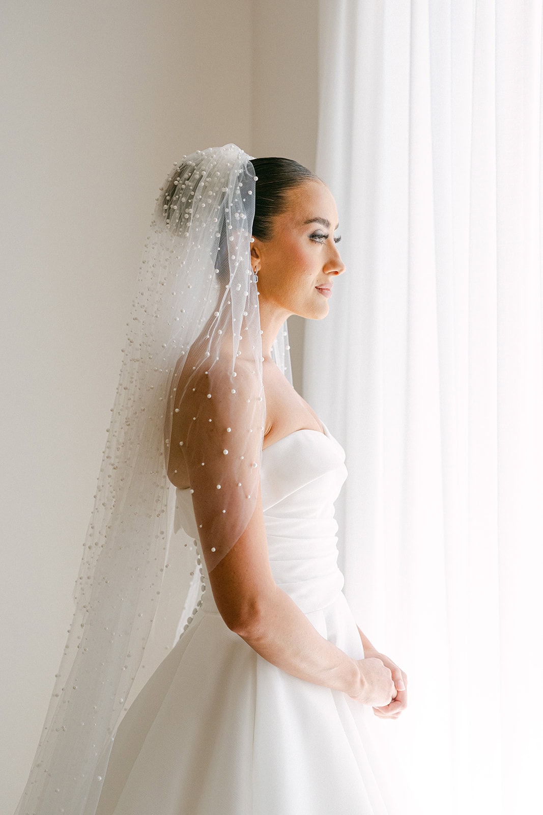 Bride standing by window after getting ready 