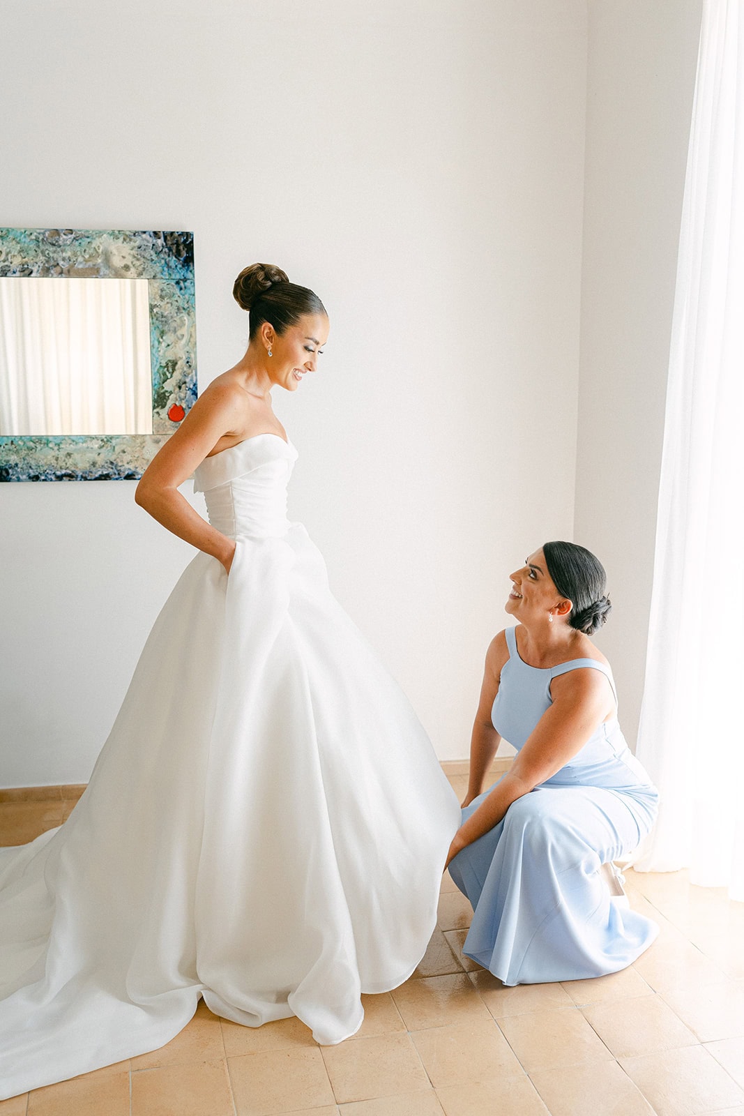 Maid of honour of the bride fixing dress during getting ready pictures wedding