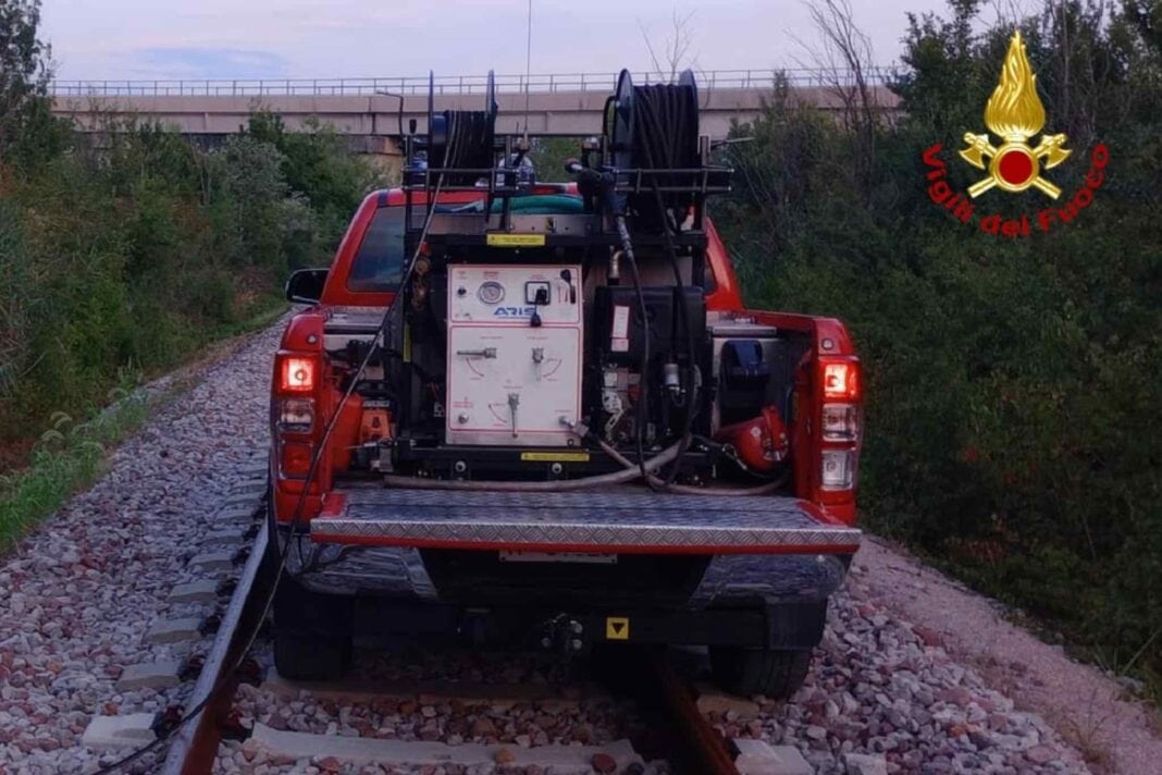 camionetta dei vigili del fuoco percorre i binari del treno