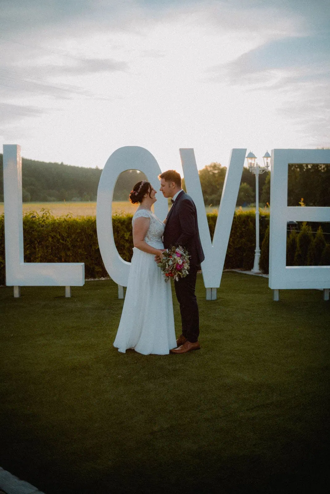 Brautpaar blickt sich an bei Sonnenuntergang im Hotel Grabinger