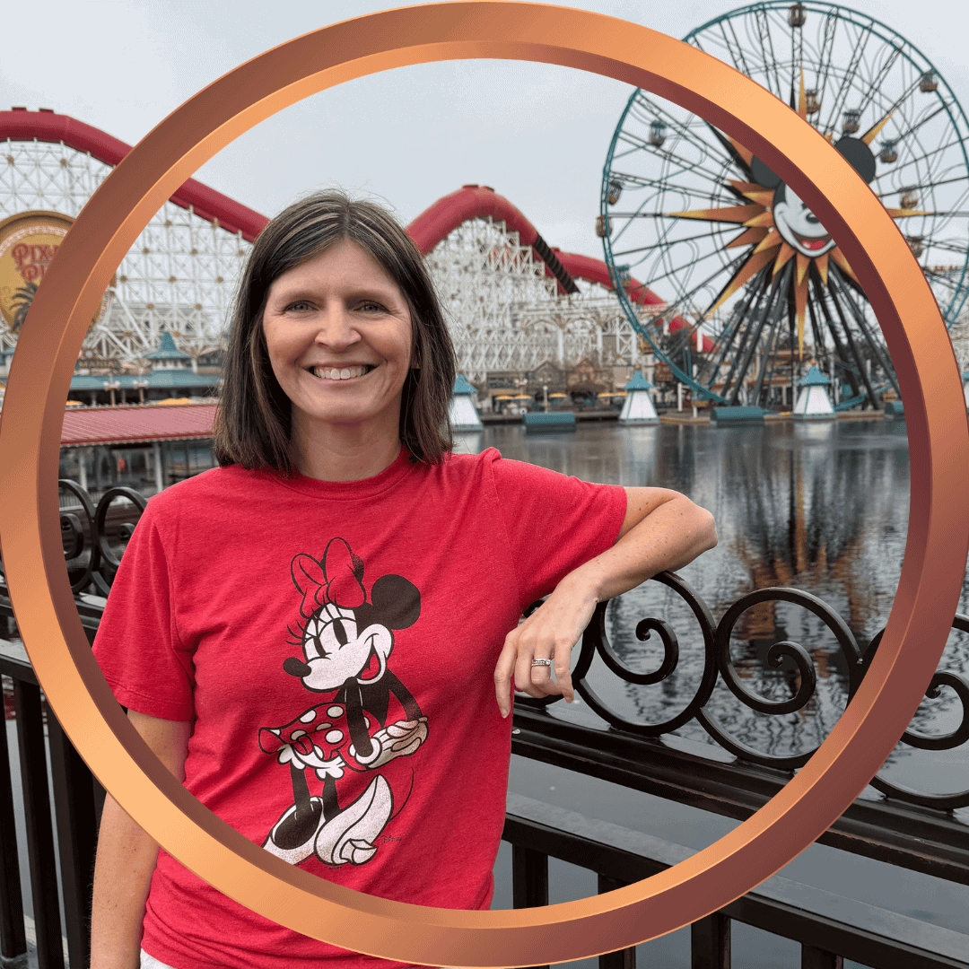 Woman smiling with Minnie Mouse shirt at Disneyland amusement park.