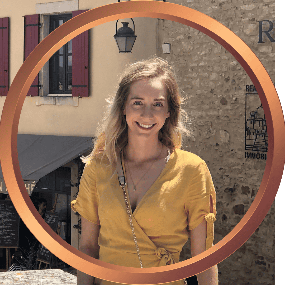 Smiling woman in yellow dress outdoors with a circular frame.