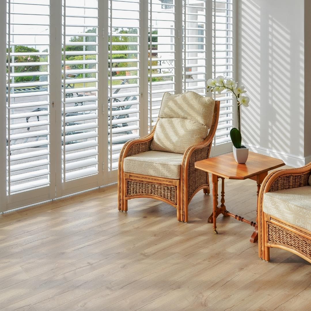 Living room with floor-to-ceiling white security shutters, offering full light control and an elegant alternative to blinds.