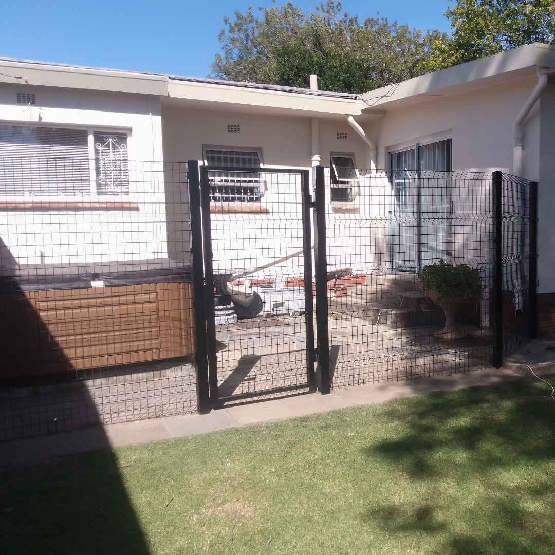 Black coated mesh Clearview fencing with integrated pedestrian gate, installed around a residential property for maximum visibility and security.