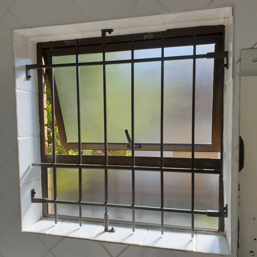 Brown mini Spanish burglar bars installed on a tiled bathroom's window.