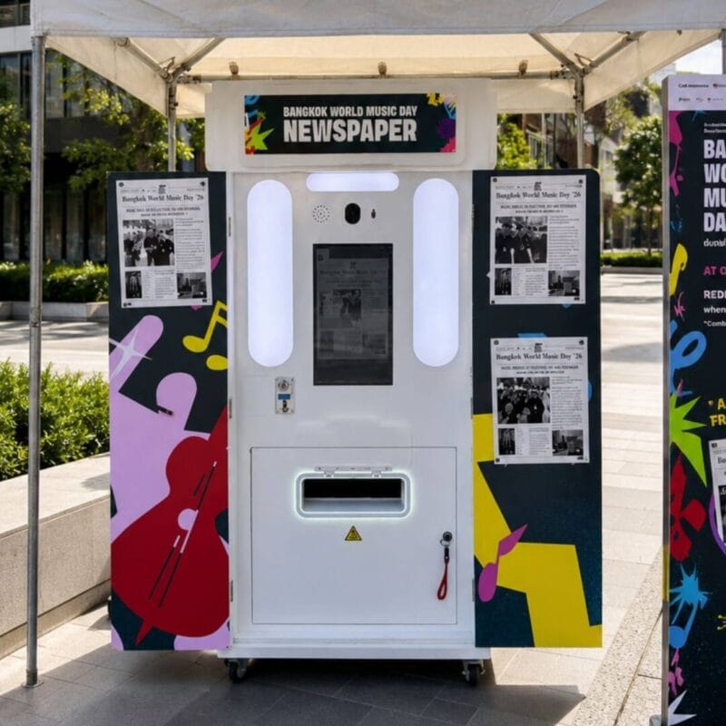 Wrapped newspaper photo booth with sample front pages on the side panels at an outdoor event