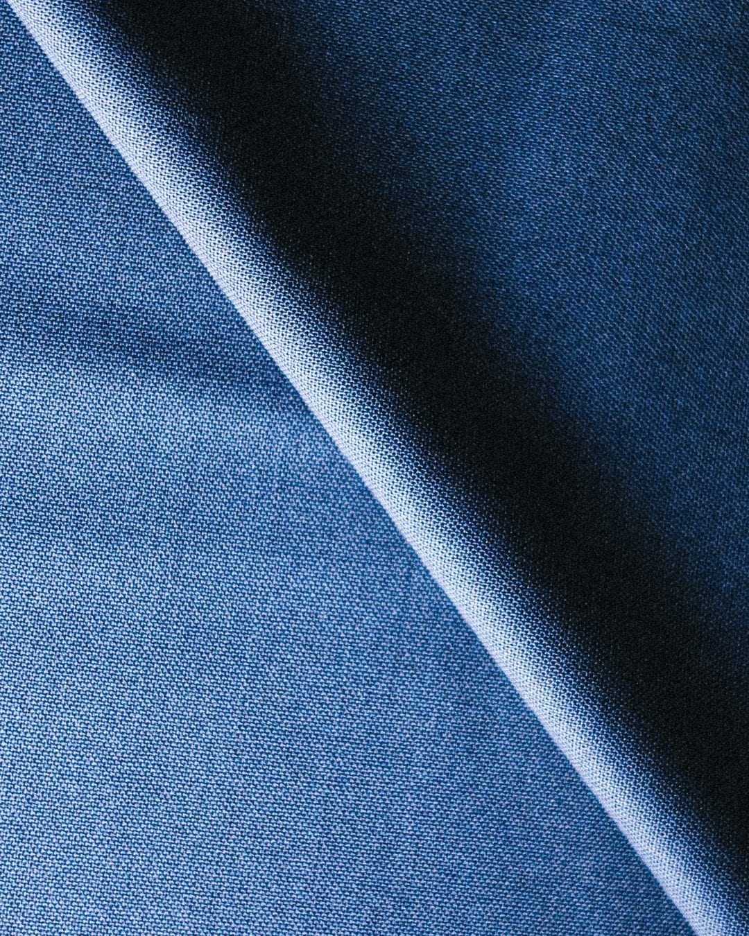 Close-up of navy wool suiting folded on the diagonal