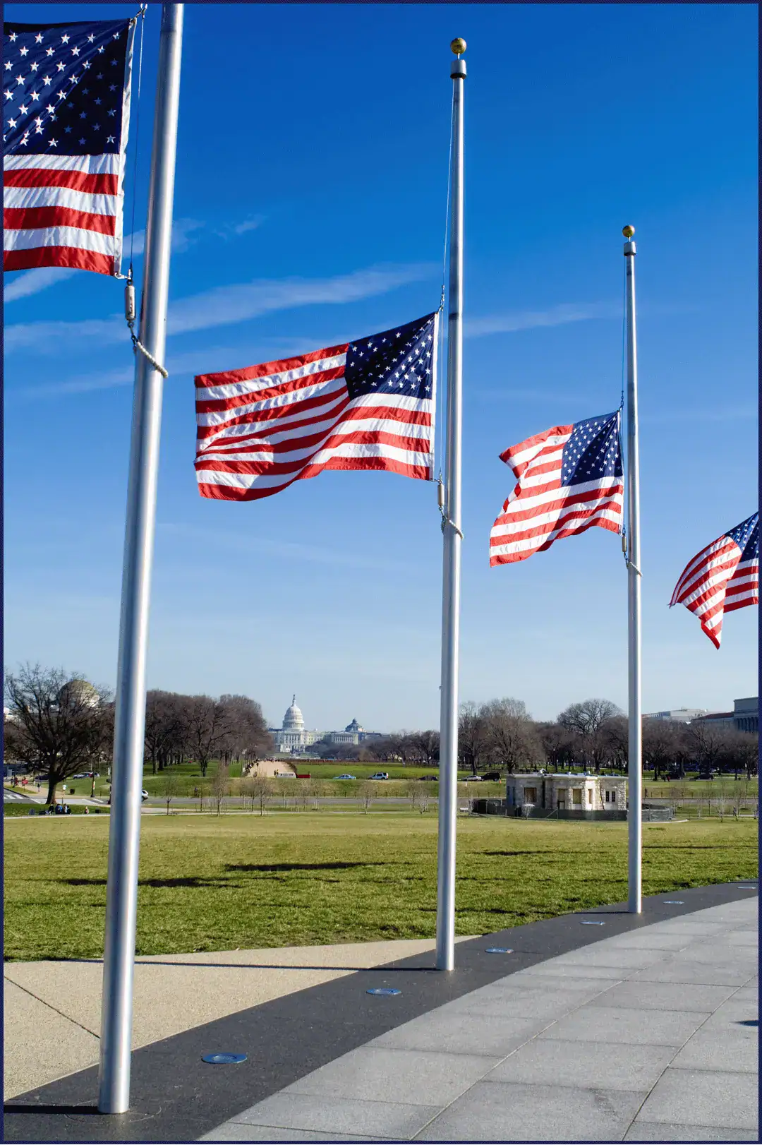 Three American flags fly at half mast