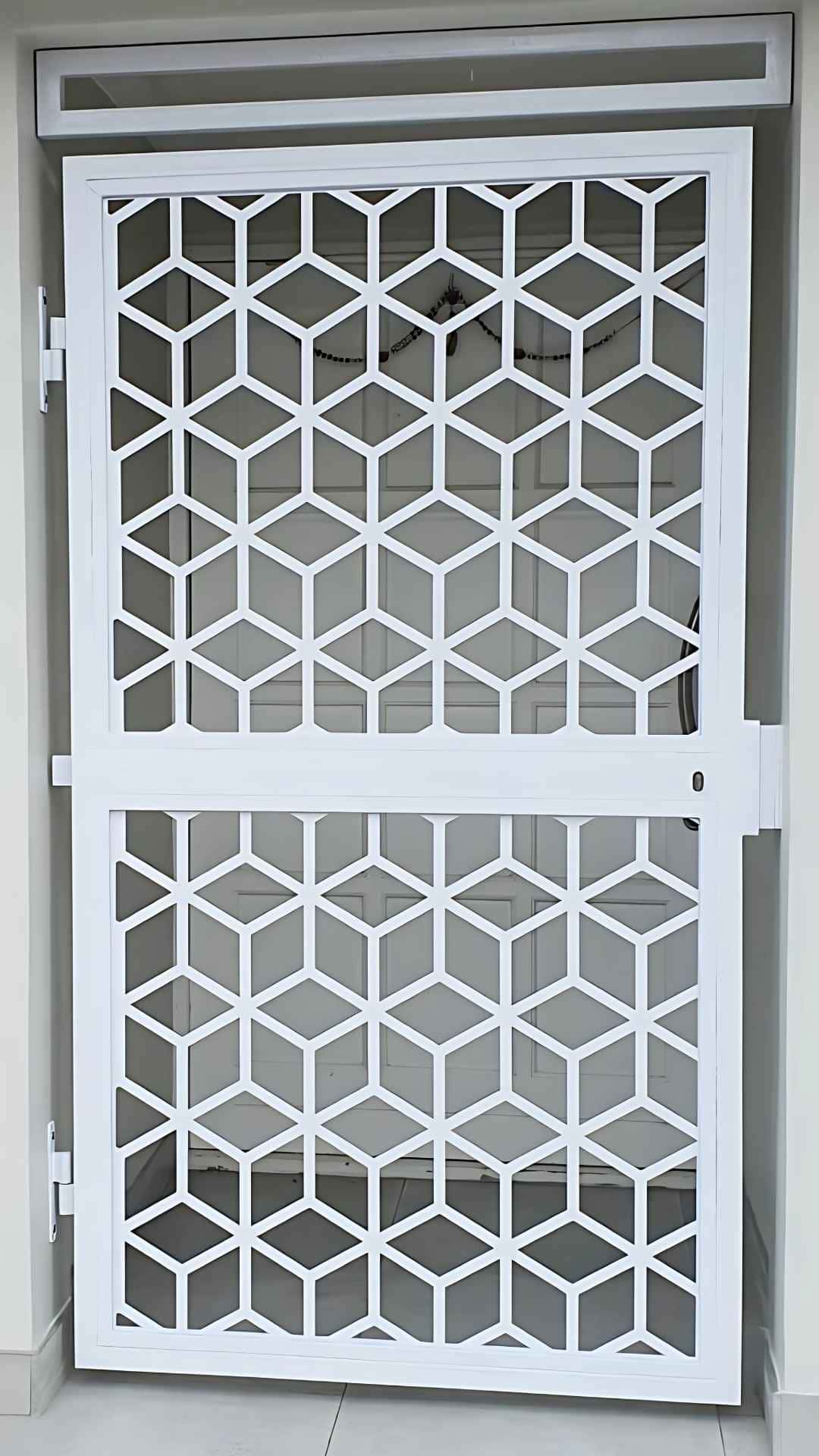 Modern custom gate with white geometric cube lattice, two-panel metal security screen for front door, left-hinged with lock style on right.