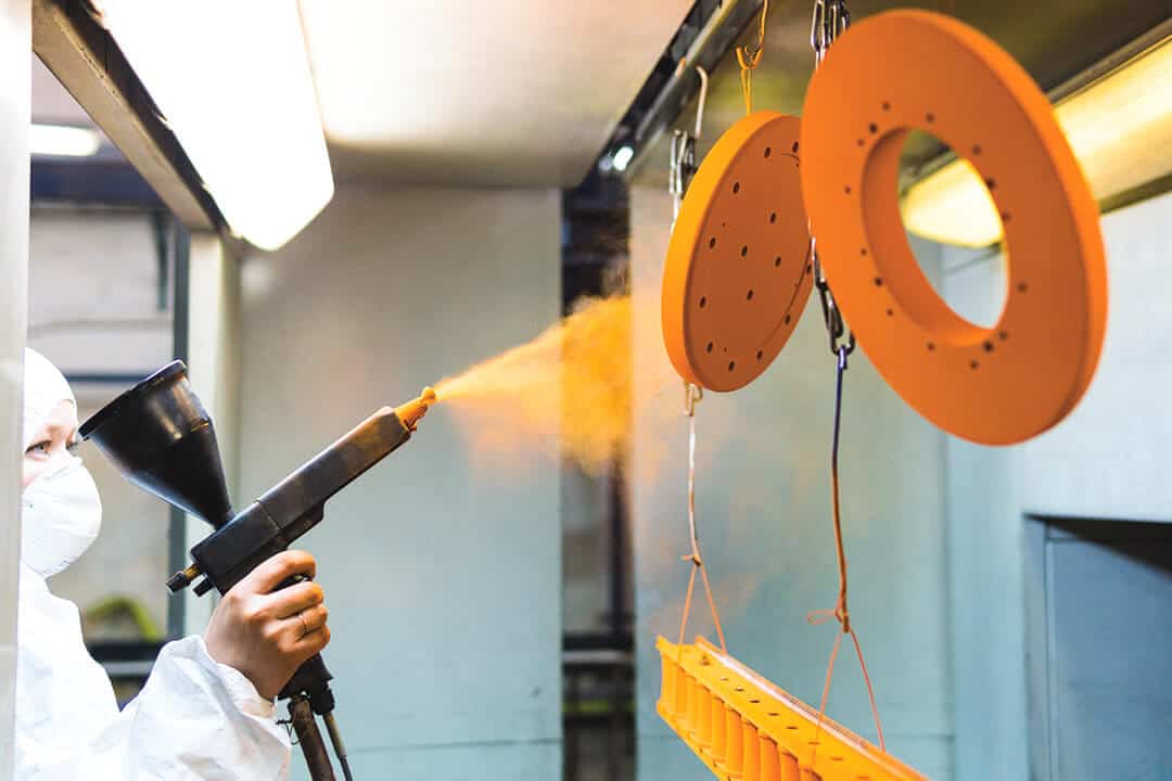 worker usng a powder coating sprayer