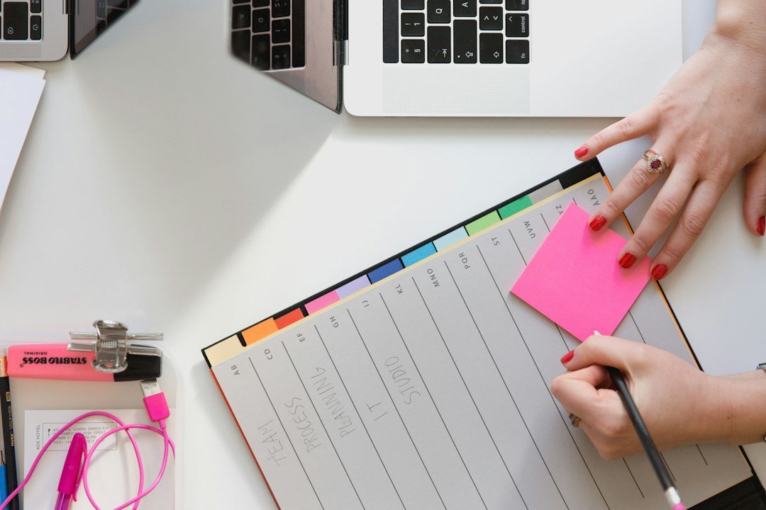 Organised LTD company desk with planner, sticky notes, and laptops