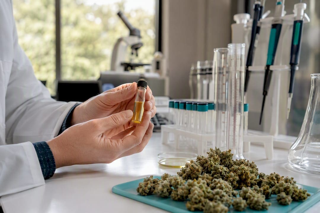 Scientist holding limonene extract vial in lab