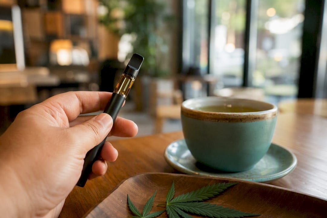 Gros plan sur une main tenant un stylo vaporisateur de cannabis