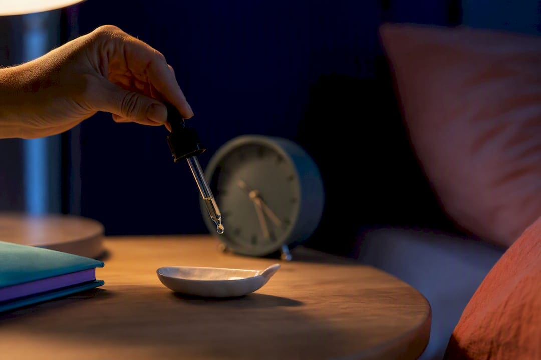 Personne qui dose des gouttes de CBD le soir