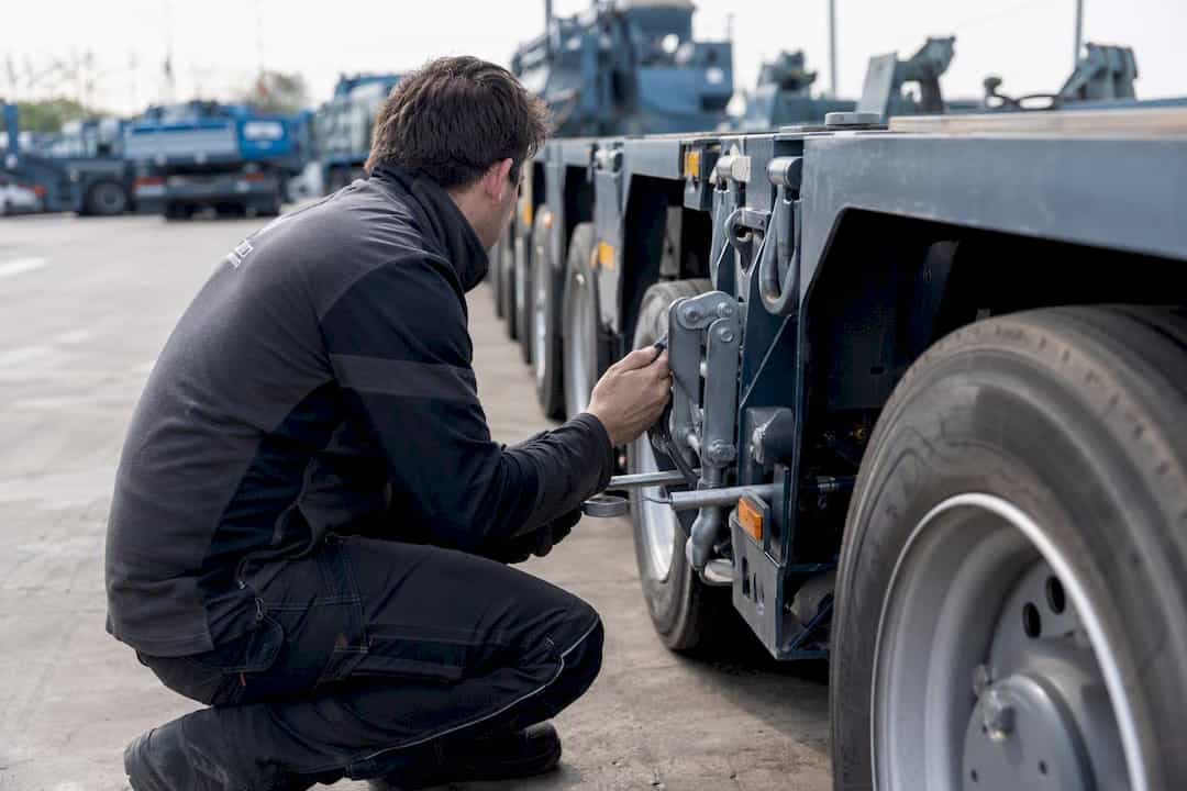 Hände, die die Befestigung an einem Transportanhänger justieren