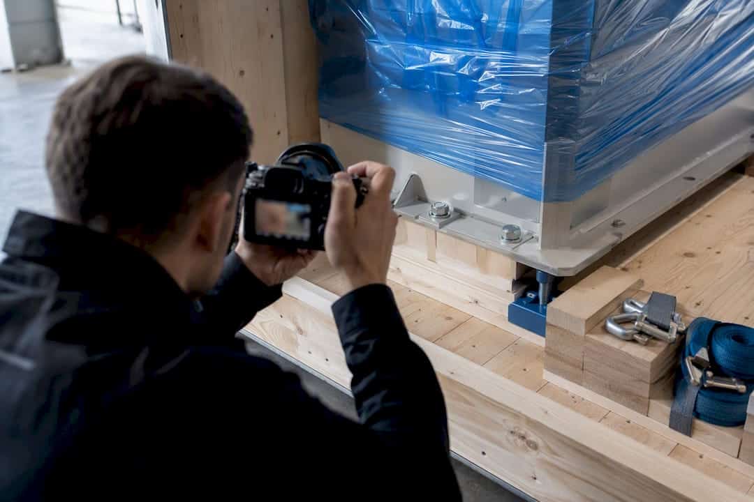Fachkraft fotografiert geschütztes Maschinenteil