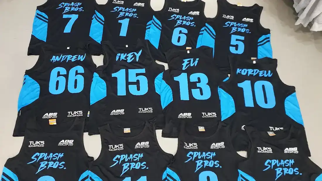 Custom screen printed basketball team singlets with player names and numbers, printed by Xpress Tees Gold Coast