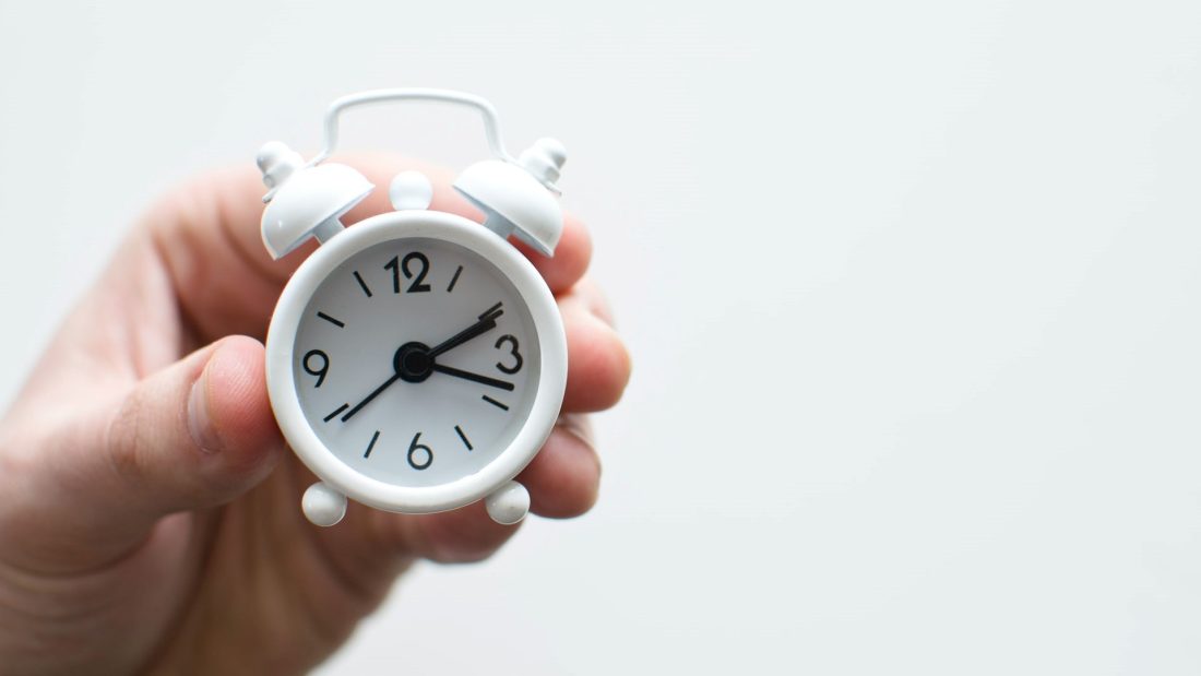 A person with a small alarm clock.