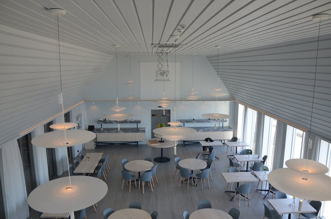 Modernt restaurang- och eventutrymme med stora fönster, ljusa ytor och elegant design, perfekt för middagar, möten och konferenser i en inspirerande miljö.