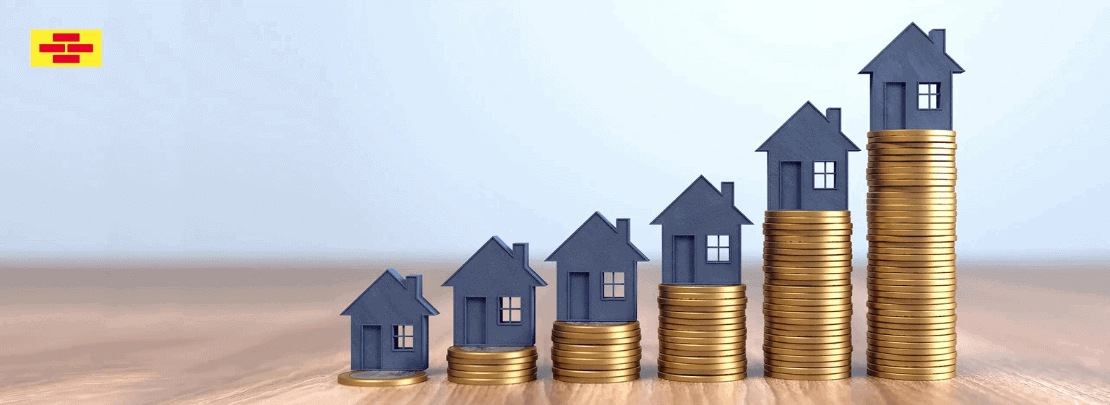 Symbolbild zur Entwicklung der Bauzinsen: gestapelte Münzen mit kleinen Häusern darauf, die einen Anstieg der Finanzierungskosten im Immobiliensektor darstellen.