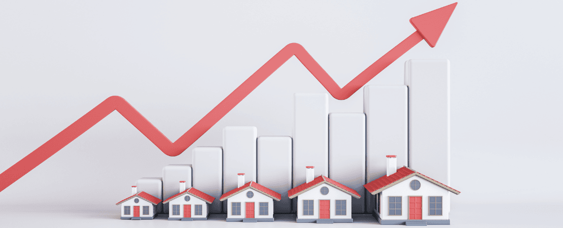 Symbolbild für Immobilienmarkt und Wertsteigerung: Kleine Modellhäuser stehen vor einer ansteigenden Balkengrafik mit einem roten Pfeil, der nach oben zeigt. Darstellung für steigende Immobilienpreise, Investitionen in den Wohnungsmarkt und Wertentwicklung von Häusern.