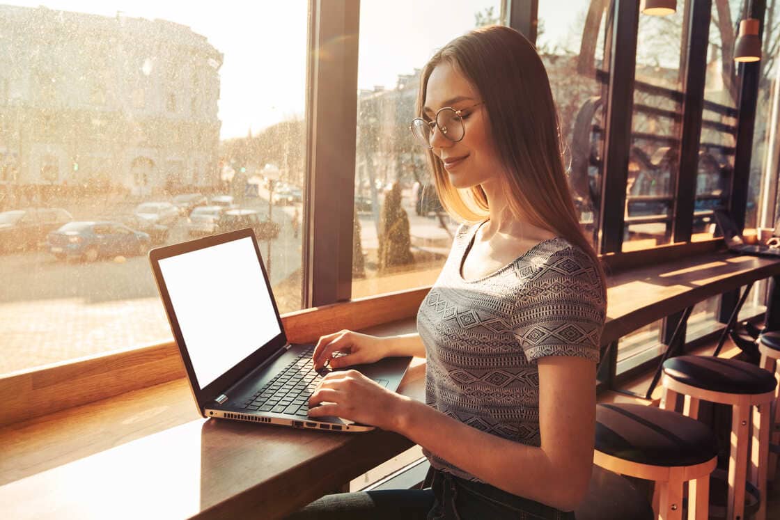 Foto de uma mulher trabalhando em frente à um notebook